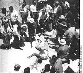 A crowd views the body of Giuliano