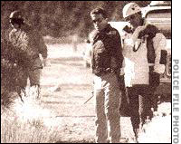 Searchers and police examine an area